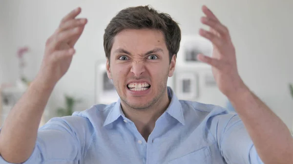 Irritado gritando bonito jovem homem reagindo ao problema no trabalho — Fotografia de Stock