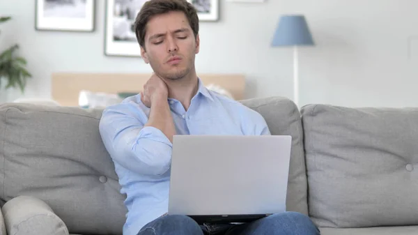 Knappe jonge man met nekpijn werken op laptop — Stockfoto