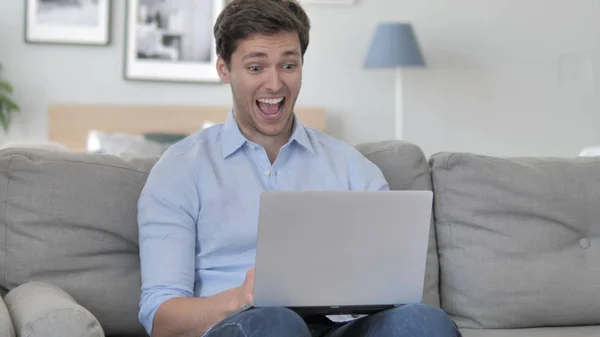 Handsome Young Man Celebrating Success on Laptop