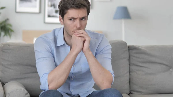 Stressad stilig ung man sittande spänd på soffan — Stockfoto