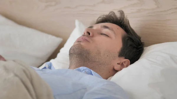 Schöner junger Mann schläft im Bett — Stockfoto