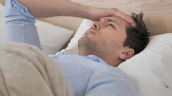 Tense Young Man with Headache Lying in Bed — Stock Photo, Image