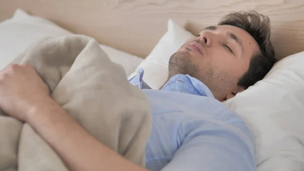 Müder junger Mann liegt zum Schlafen im Bett — Stockfoto