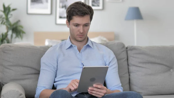 Beau jeune homme naviguant sur Internet sur tablette — Photo