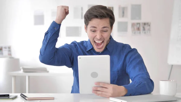 Gelegenheitserwachsener Mann begeistert für Ergebnisse auf Tablet — Stockfoto
