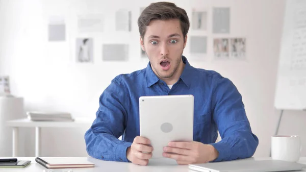 Příležitostný dospělý muž v šoku při používání tabletu — Stock fotografie