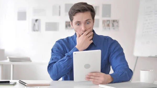 Je me demande jeune homme étonné par les résultats tout en utilisant la tablette — Photo