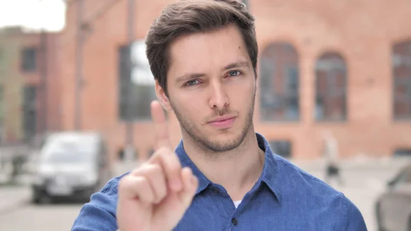 No, Young Man Rejecting Offer by Waving Finger
