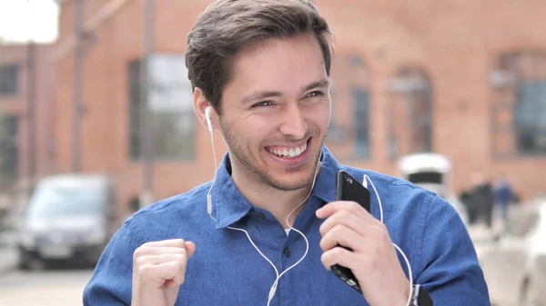 Jovem feliz ouvindo música em Smartphone — Fotografia de Stock