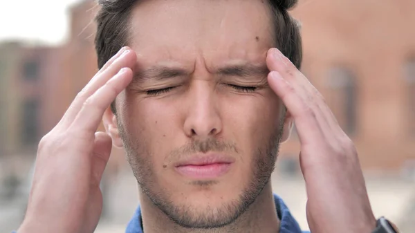 Primer plano al aire libre del joven con dolor de cabeza — Foto de Stock