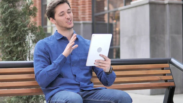 Video Chat on Tablet by Young Man Sitting on Bench — Stock Photo, Image