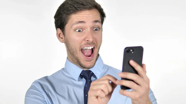 Jungunternehmer feiert Erfolg mit Smartphone auf weißem Hintergrund — Stockfoto