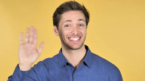 Casual Young Man Waving Hand to Welcome on Yellow Background — Fotografie, imagine de stoc