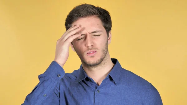 Hombre joven casual con dolor de cabeza sobre fondo amarillo — Foto de Stock