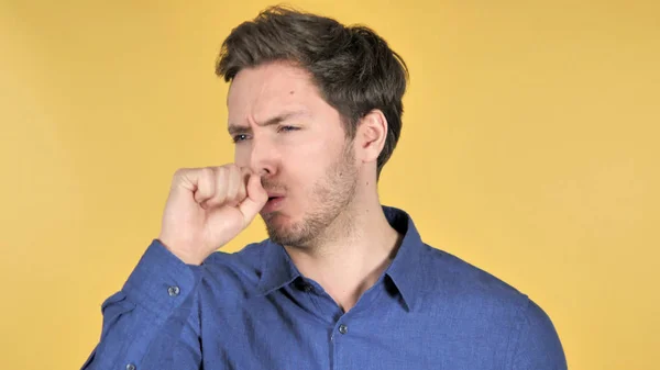 Hombre joven ocasional tosiendo sobre fondo amarillo —  Fotos de Stock