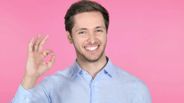 Gest av okej av ung man på rosa bakgrund — Stockfoto