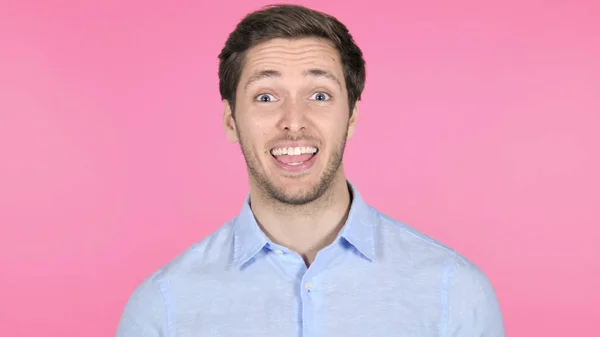 Онлайн видео чат молодого человека на розовом фоне — стоковое фото