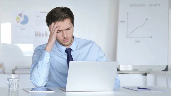 Gestresster Jungunternehmer sitzt verärgert bei der Arbeit — Stockfoto