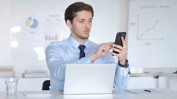 Multitasking Businessman Using Smartphone, Tablet and Laptop at Work