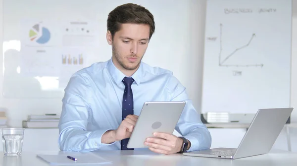 Jovem empresário usando tablet no escritório — Fotografia de Stock