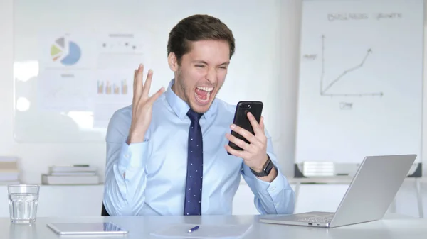 Young Businessman Celebrating Success on Smartphone — Stock Photo, Image