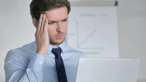 Nahaufnahme eines jungen Geschäftsmannes mit Kopfschmerzen bei der Arbeit im Büro — Stockfoto