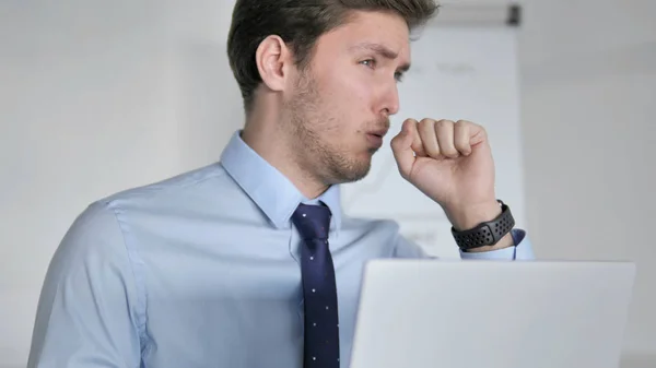 Nahaufnahme eines jungen Geschäftsmannes, der bei der Arbeit hustet — Stockfoto