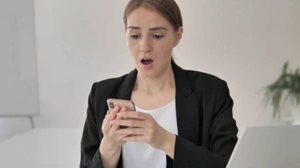 Joven mujer de negocios molesta por la pérdida en el teléfono inteligente — Foto de Stock