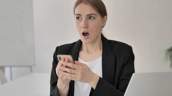 Шокированная молодая предпринимательница с помощью смартфона — стоковое фото