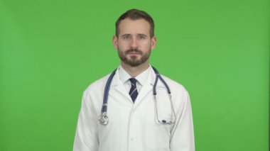 Yakışıklı Doktor Chroma Key karşı Kamera bakıyor