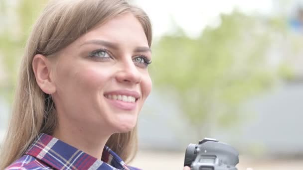美丽的女人摄影师微笑，而持有相机 — 图库视频影像