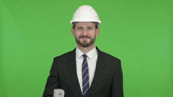 Engenheiro alegre mostrando plano de construção contra Chroma Key — Vídeo de Stock