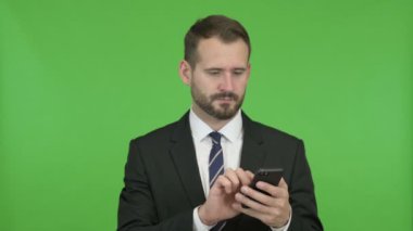 Neşeli İşadamı Chroma Key karşı Cep Telefonu kullanırken Heyecanlı alıyorum