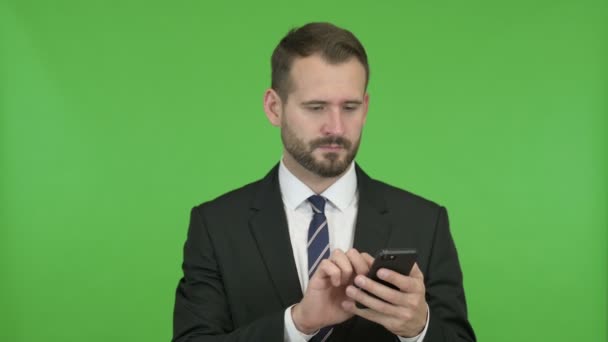 Veselý podnikatel se rozčiluje při používání mobilního telefonu proti Chromovu klíči — Stock video