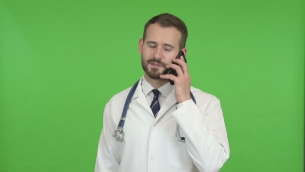 Jeune médecin masculin parlant au téléphone contre Chroma Key — Video