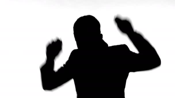 Silhouette di allegro giovane uomo godendo di ballare da solo — Video Stock