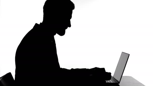 Silhouet van boze man werken op laptop en krijgen gestrest — Stockvideo