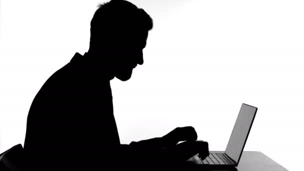 Silhouette of Cheerful Man Celebrating Success while working on Laptop — стоковое видео