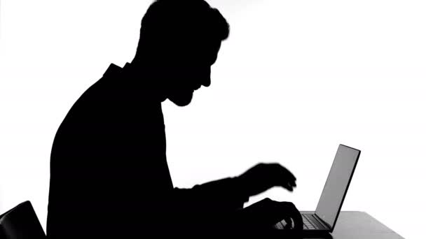 Silhouette av man som har huvudvärk medan du arbetar på laptop — Stockvideo