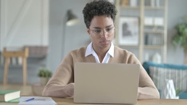 Africká dívka opouštějící přenosný počítač na stole po dokončení práce — Stock video