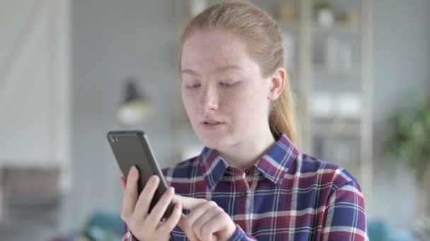 Mujer joven usando el teléfono y sintiéndose emocionada — Vídeos de Stock