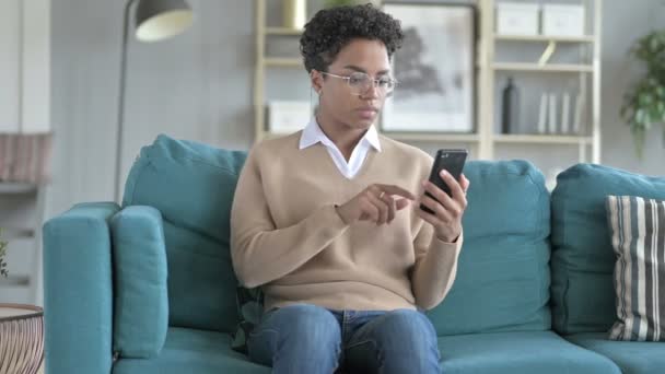 Africano menina ficar surpreso enquanto rolando no telefone — Vídeo de Stock