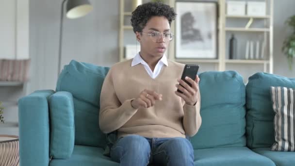 Joven africana chica obtener estresado mientras se desplaza el teléfono — Vídeos de Stock