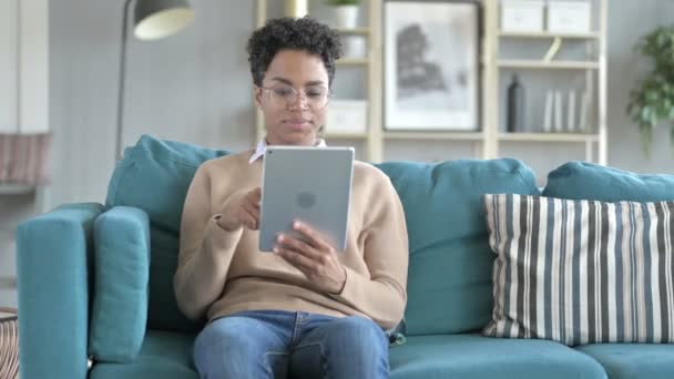 Joven africana chica es desplazamiento su tableta — Vídeo de stock