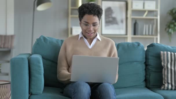 Веселая африканская девушка работает на ноутбуке — стоковое видео