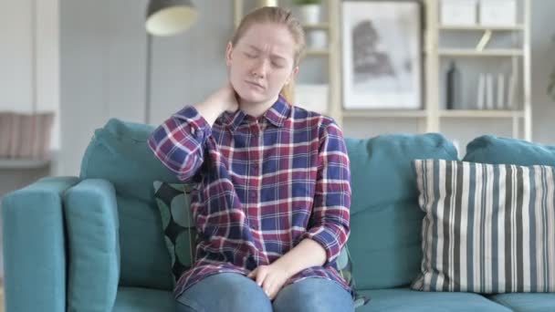 Junge Frau sitzt während sie Nackenschmerzen hat — Stockvideo