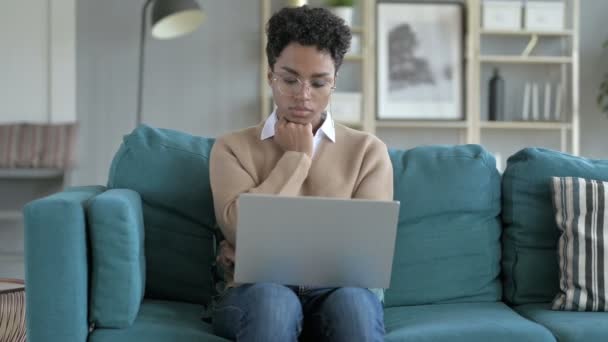Задумчивая африканская девушка работает на ноутбуке — стоковое видео