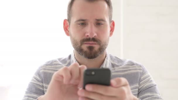 Emocionado homem torcendo sucesso em Smartphone — Vídeo de Stock