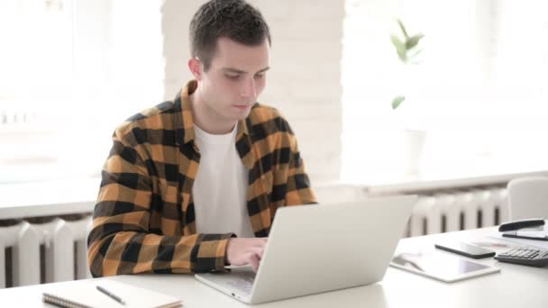 Випадковий молодий чоловік працює на ноутбуці — стокове відео
