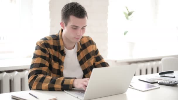 Випадковий молодий чоловік введення на ноутбук — стокове відео